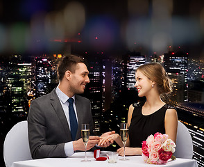 Image showing man proposing to his girlfriend at restaurant