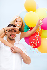 Image showing couple with colorful balloons at seaside