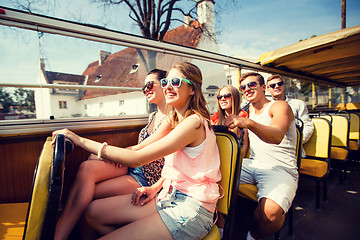 Image showing group of smiling friends traveling by tour bus