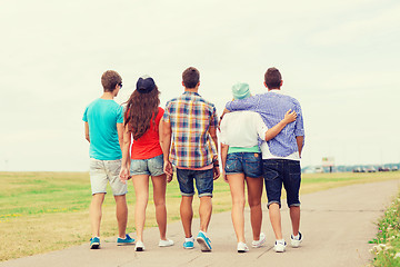 Image showing group of teenagers walking outdoors from back