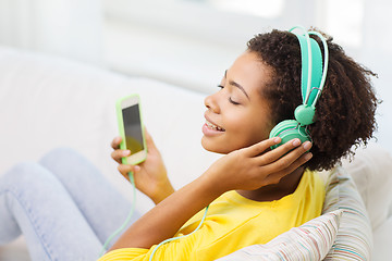 Image showing happy african woman with smartphone and headphones