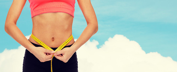 Image showing close up of female hands measuring waist