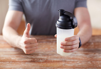 Image showing man with protein shake bottle showing thumbs up