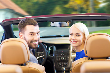 Image showing happy couple driving in cabriolet car over city