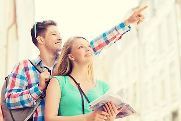 Image showing smiling couple with city guide and backpack