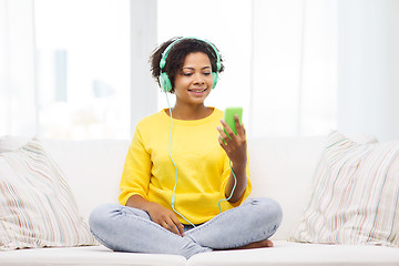 Image showing happy african woman with smartphone and headphones