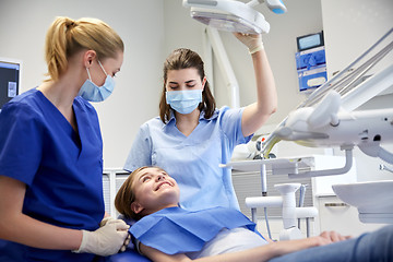 Image showing happy female dentist with patient girl at clinic