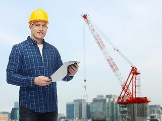 Image showing smiling male builder in helmet with clipboard