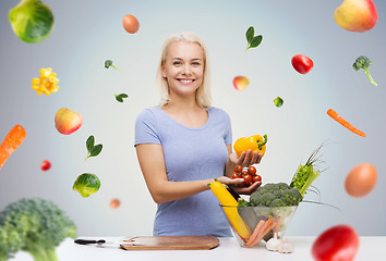 Image showing smiling young woman cooking vegetables at home