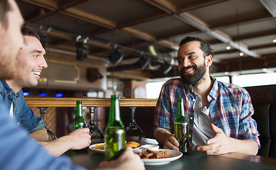 Image showing happy male friends drinking beer at bar or pub