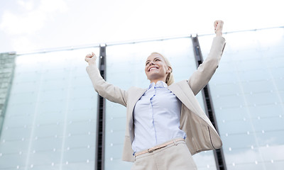 Image showing young smiling businesswoman over office building