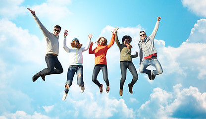 Image showing smiling friends in sunglasses jumping high