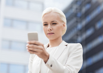 Image showing serious businesswoman with smartphone outdoors