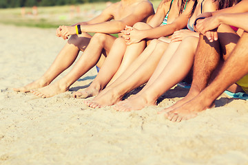 Image showing close up of friends sitting on summer beach