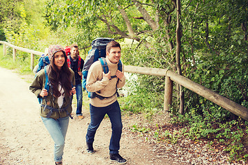 Image showing group of smiling friends with backpacks hiking