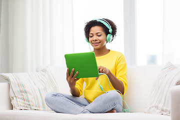 Image showing happy african woman with tablet pc and headphones