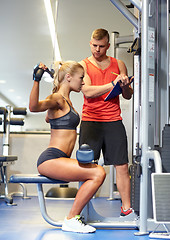 Image showing man and woman flexing muscles on gym machine