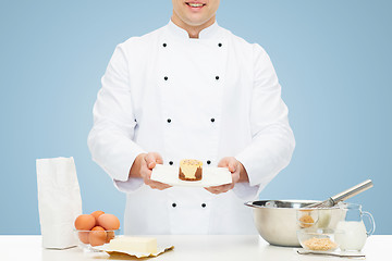 Image showing close up of happy male chef cook baking dessert