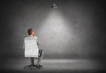 Image showing businessman in office chair over white board