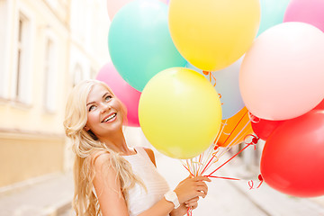 Image showing smiling woman with colorful balloons