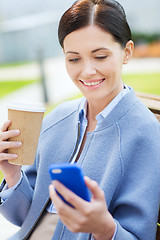 Image showing smiling woman with coffee and smartphone