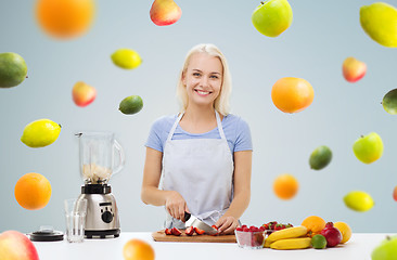 Image showing smiling woman with blender preparing fruit shake