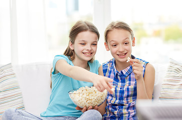 Image showing happy girls with popcorn watching tv at home