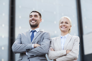 Image showing smiling businessmen standing over office building