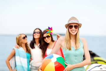 Image showing girl with ball and friends on the beach