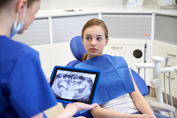 Image showing dentist showing x-ray on tablet pc to patient girl