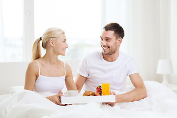 Image showing happy couple having breakfast in bed at home