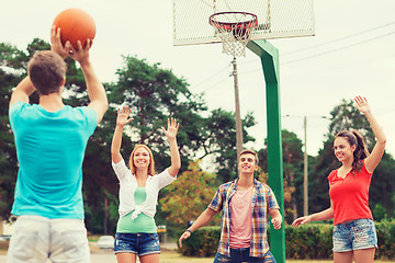 Image showing group of smiling teenagers playing basketball