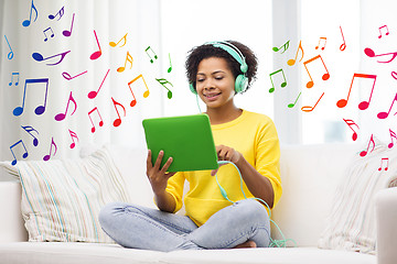 Image showing happy african woman with tablet pc and headphones