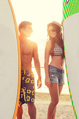 Image showing smiling couple in sunglasses with surfs on beach