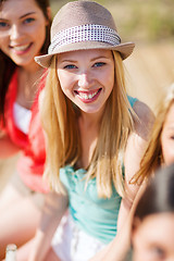 Image showing girl with drink and friends on the beach