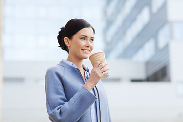 Image showing smiling woman drinking coffee in city