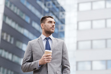 Image showing young serious businessman with paper cup outdoors