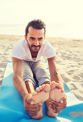 Image showing man doing yoga exercises outdoors