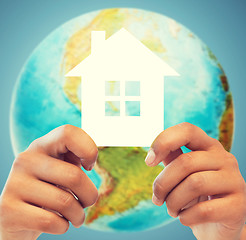 Image showing couple hands holding green house over earth globe