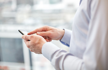 Image showing close up of man hands with smartphone at office