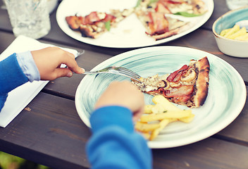 Image showing close up of child hands having dinner outdoors