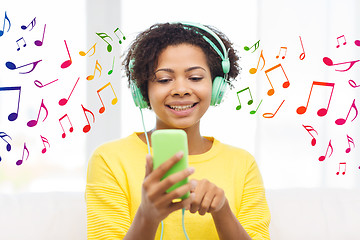 Image showing happy african woman with smartphone and headphones