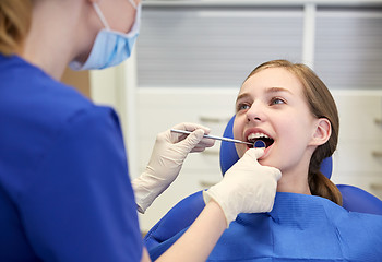 Image showing female dentist checking patient girl teeth