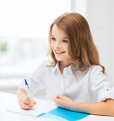 Image showing student girl writing in notebook at school