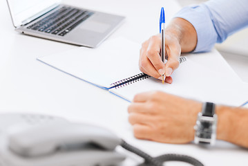 Image showing businessman writing in notebook