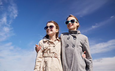 Image showing happy little girls in sunglasses hugging outdoors