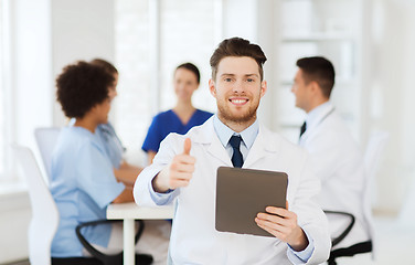 Image showing happy doctor with tablet pc over team at clinic