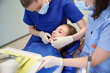 Image showing happy female dentist with patient girl at clinic