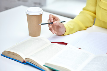 Image showing close up of female hands with books and coffee