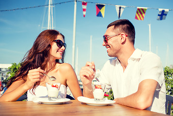 Image showing smiling couple eating dessert at cafe